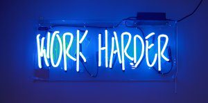 neon light sign that says work harder